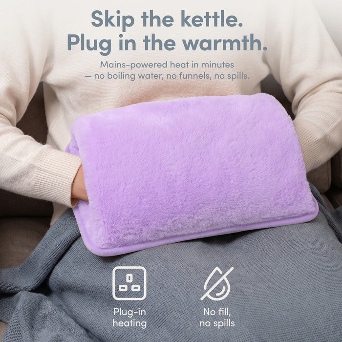 Lilac rechargeable hot water bottle on lap, plug-in heat with no filling or spills