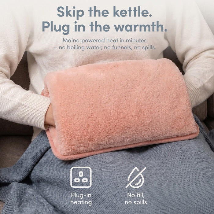 Blush rechargeable hot water bottle on lap, plug-in heat with no filling or spills