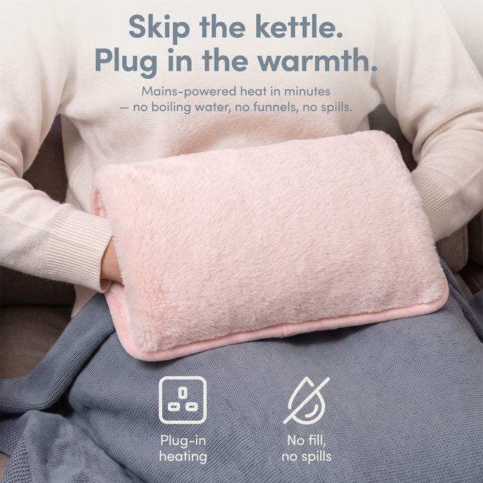 Blush rechargeable hot water bottle on lap, plug-in heat with no filling or spills