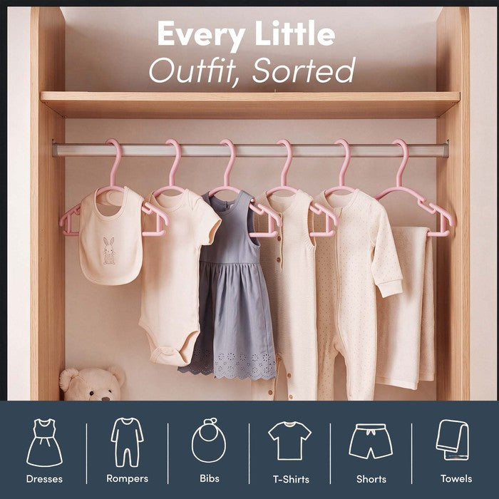 Nursery wardrobe rail sorted with dresses, rompers and bibs on pink hangers