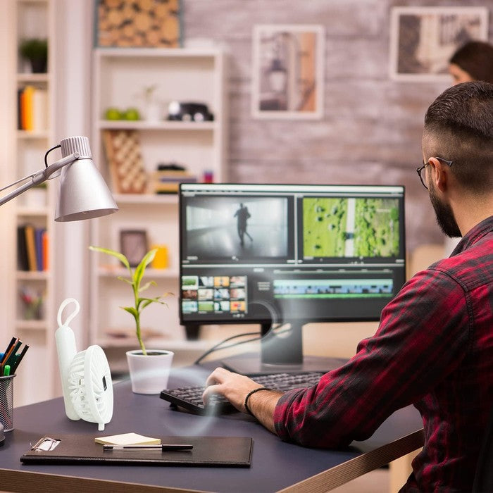 Keplin white handheld fan in folded position on a home office desk, used as a personal cooling fan
