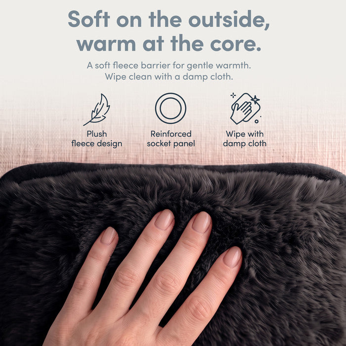 Hand on plush Black fleece cover of electric hot water bottle, wipe clean when needed