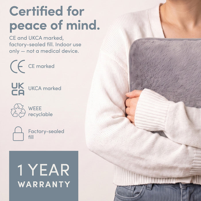 Grey electric hot water bottle held close, CE and UKCA marked with 1 year warranty