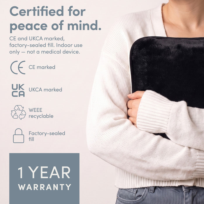 Black electric hot water bottle held close, CE and UKCA marked with 1 year warranty