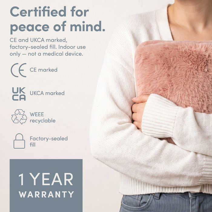 Blush electric hot water bottle held close, CE and UKCA marked with 1 year warranty