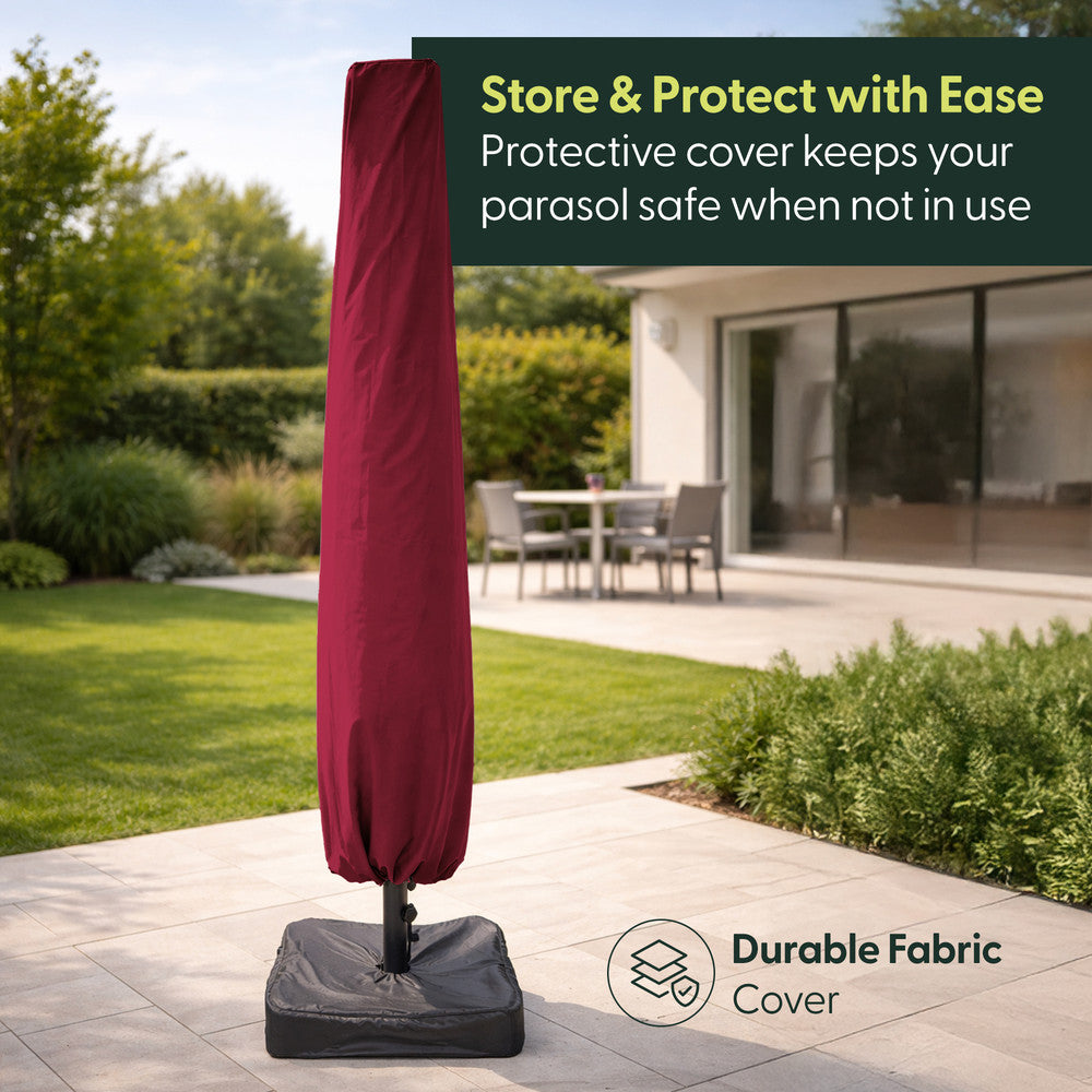 Red double parasol stored in protective fabric cover on weighted base in a garden
