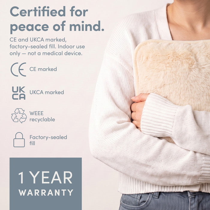 Cream electric hot water bottle held close, CE and UKCA marked with 1 year warranty