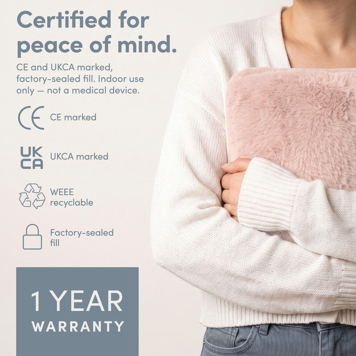 Blush electric hot water bottle held close, CE and UKCA marked with 1 year warranty