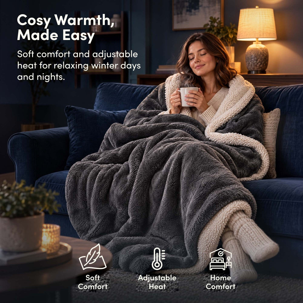Woman relaxing on sofa under charcoal grey electric heated throw blanket with sherpa lining
