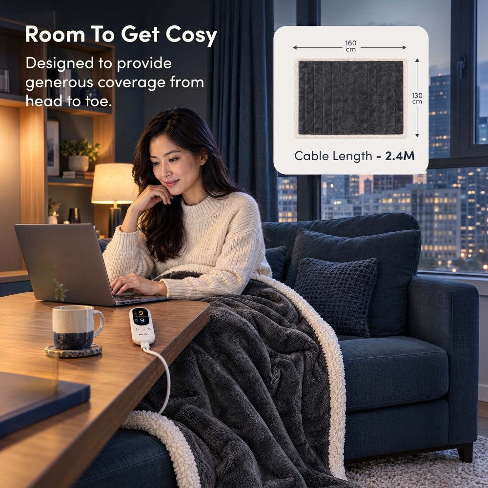 Woman on laptop under charcoal grey electric throw, 160 x 130cm size with 2.4m cable