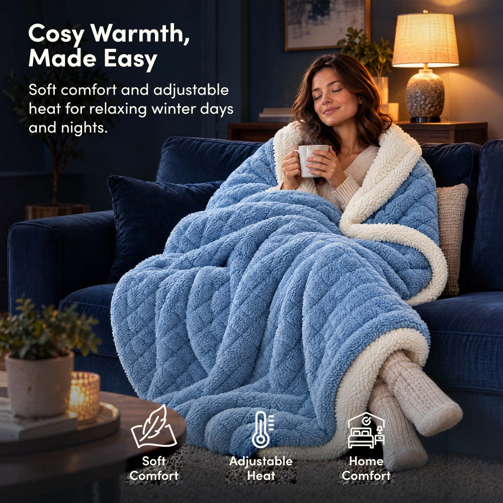 Woman relaxing on sofa under blue jacquard electric heated throw blanket with sherpa lining