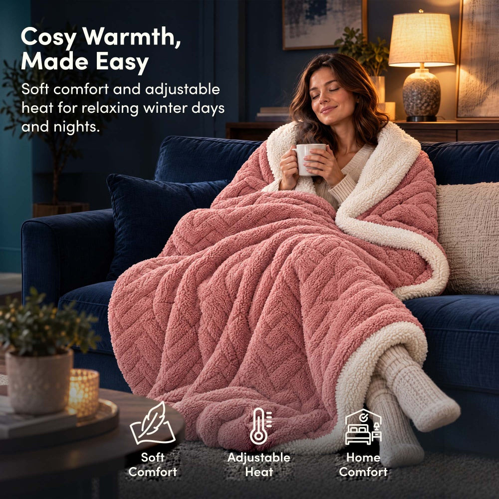 Woman relaxing on sofa under rose pink jacquard electric heated throw blanket with sherpa lining