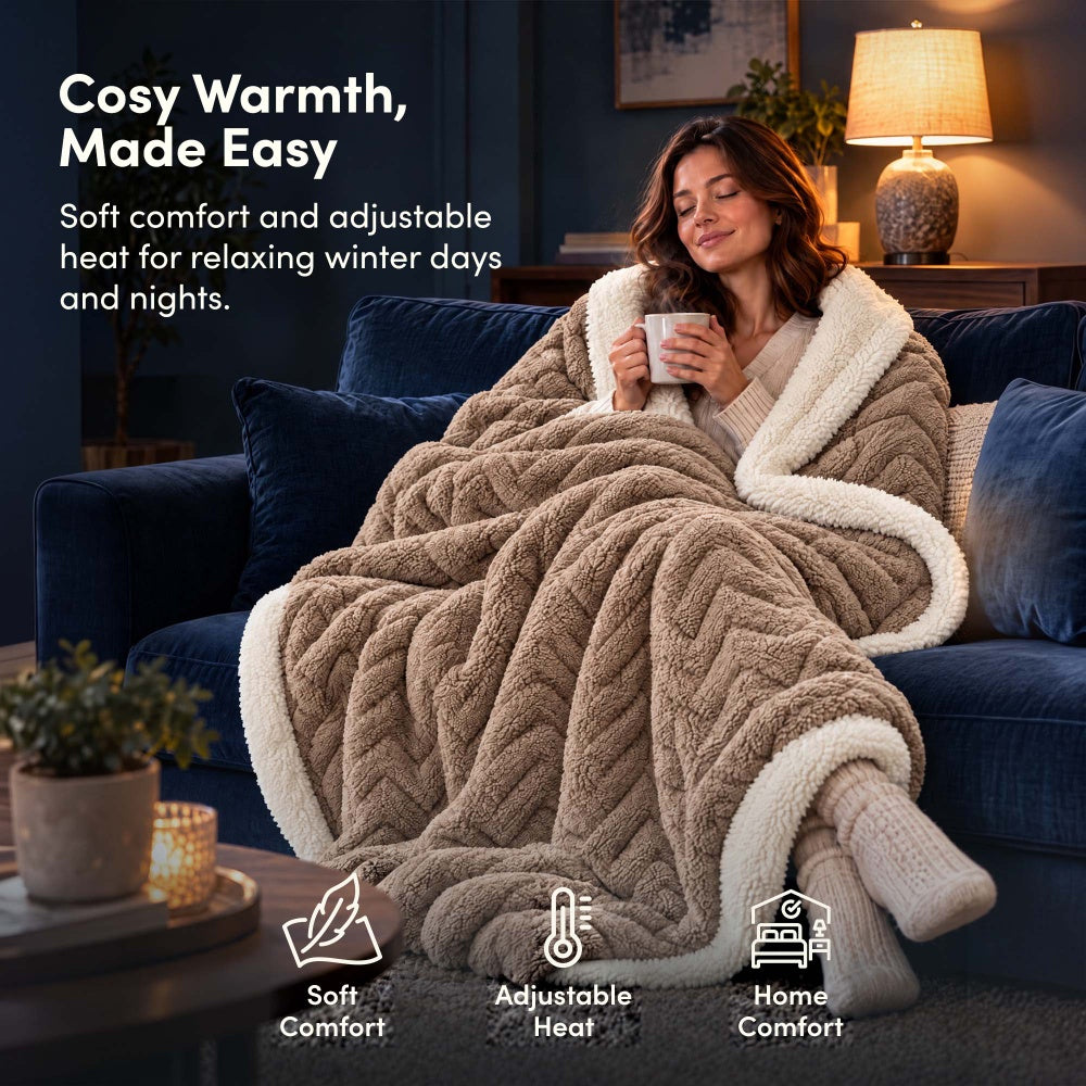 Woman relaxing on sofa under taupe jacquard electric heated throw blanket with sherpa lining