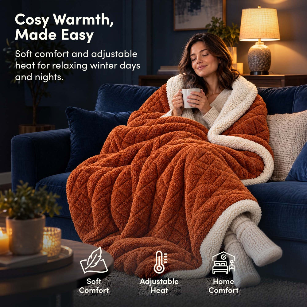 Woman relaxing on sofa under terracotta jacquard electric heated throw blanket with sherpa lining