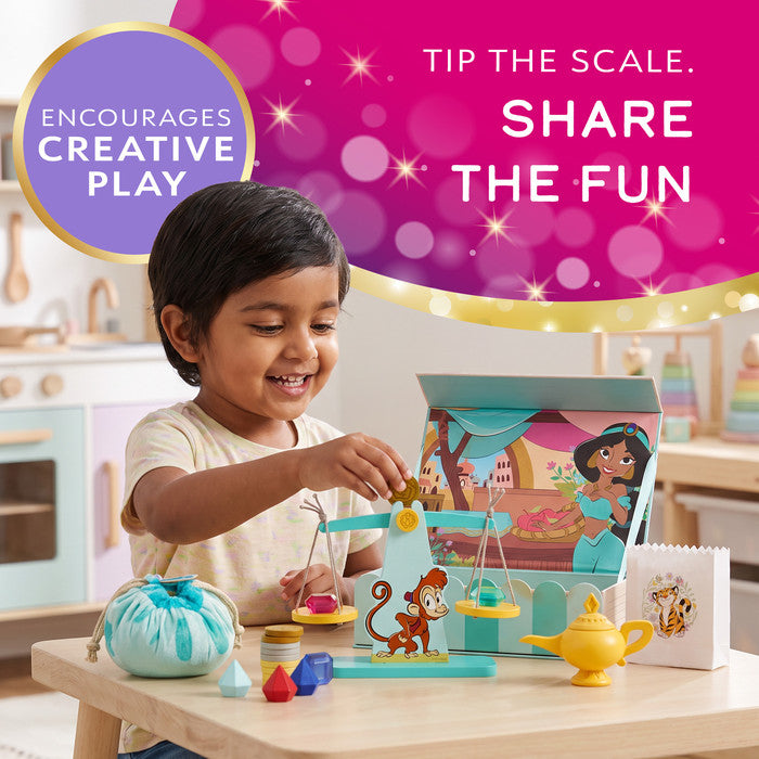 Boy weighing toy gems on the scales of a Disney Princess Jasmine wooden market play set