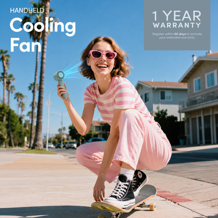 Haze green handheld cooling fan with 1-year warranty – lifestyle image outdoors