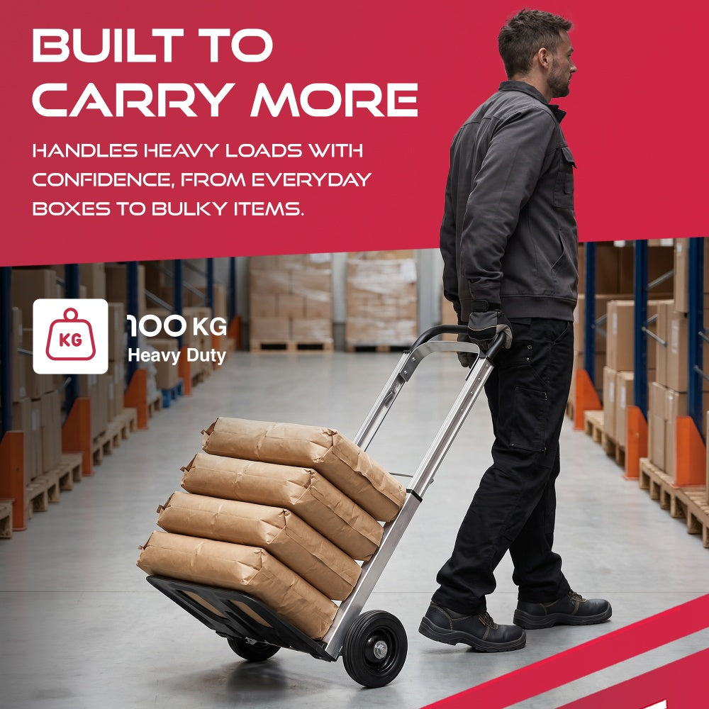 Man pulling a Haltons hand truck loaded with four sacks through a warehouse with a 100kg heavy duty badge
