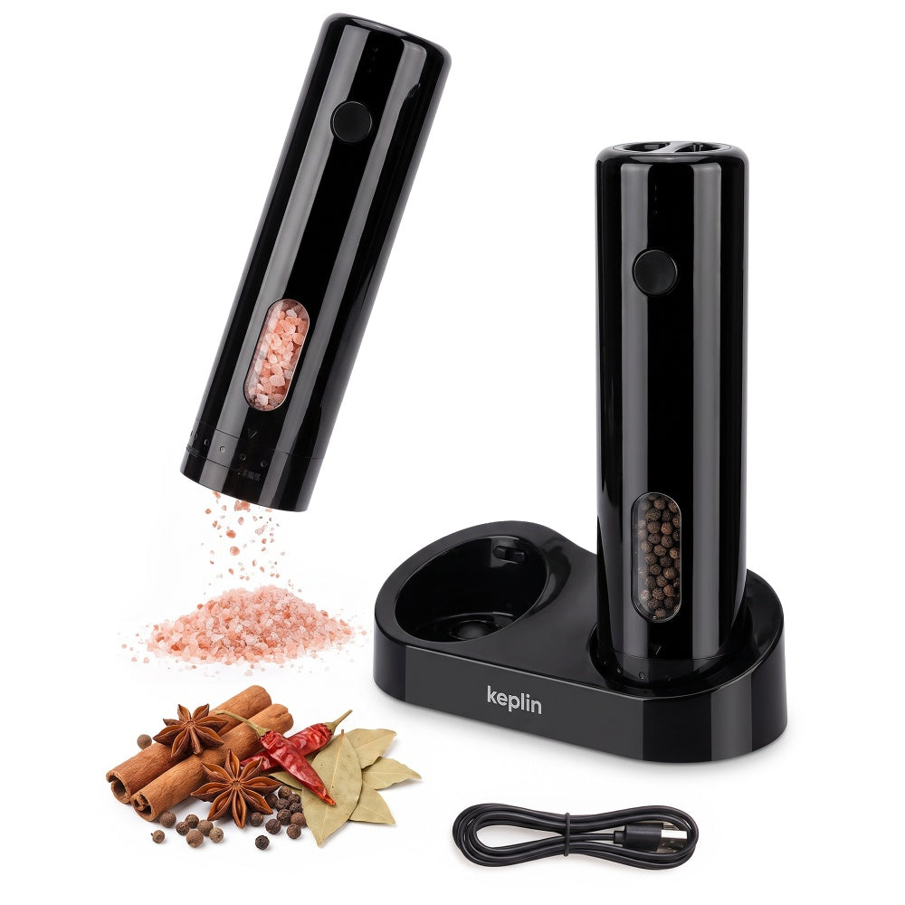 Black rechargeable mill grinding pink salt beside its charging base with USB-C cable and whole spices