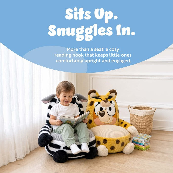 Toddler reading a book in a Bluey plush sofa chair, cosy high-back seat