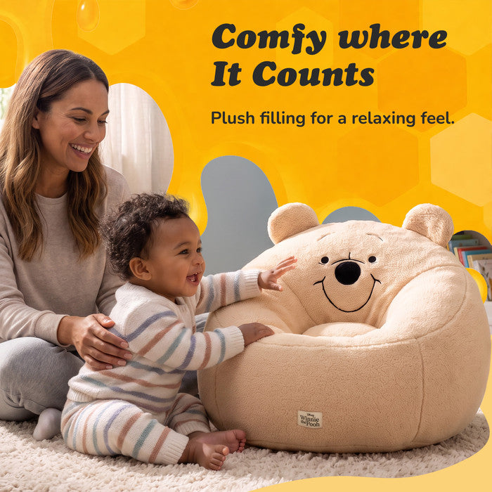 Toddler reaching for the Winnie the Pooh snuggle chair's soft plush filling