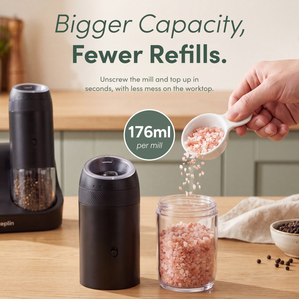 Pink salt being spooned into the clear 176ml hopper of an unscrewed black gravity mill