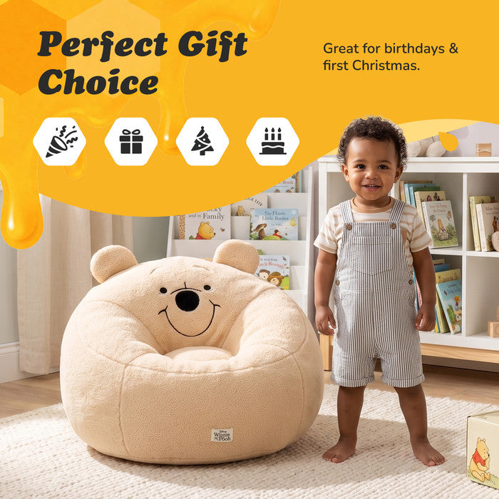 Toddler standing beside the Winnie the Pooh snuggle chair, a gift for birthdays and Christmas