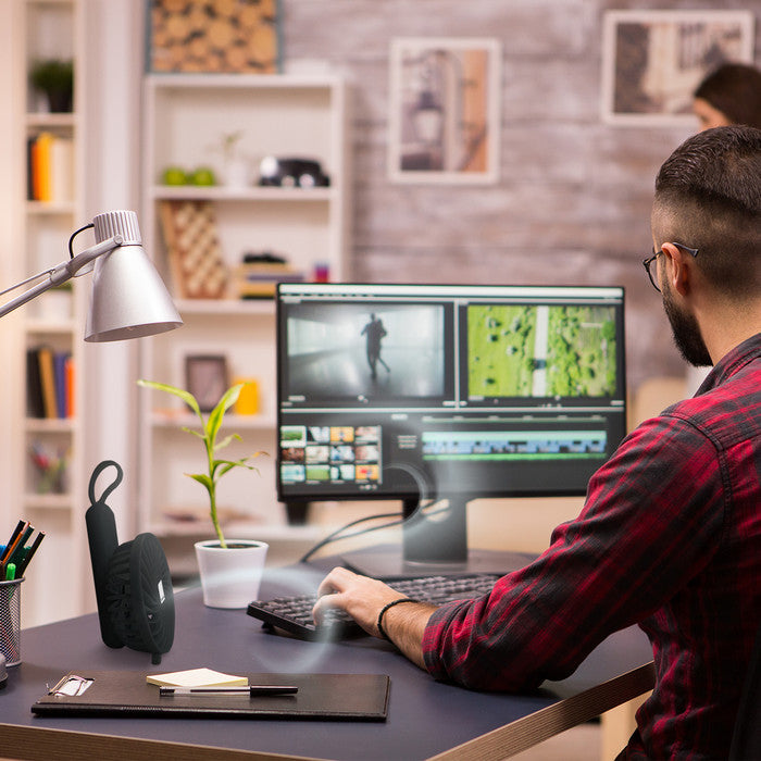 eplin black handheld fan in folded position on a home office desk, used as a personal cooling fan