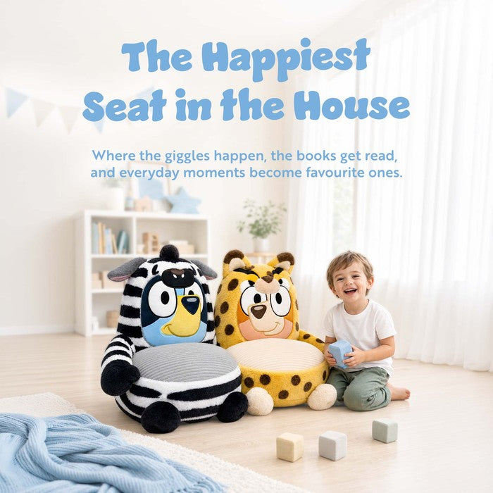 Child standing beside Bluey plush sofa chairs in a playroom setting