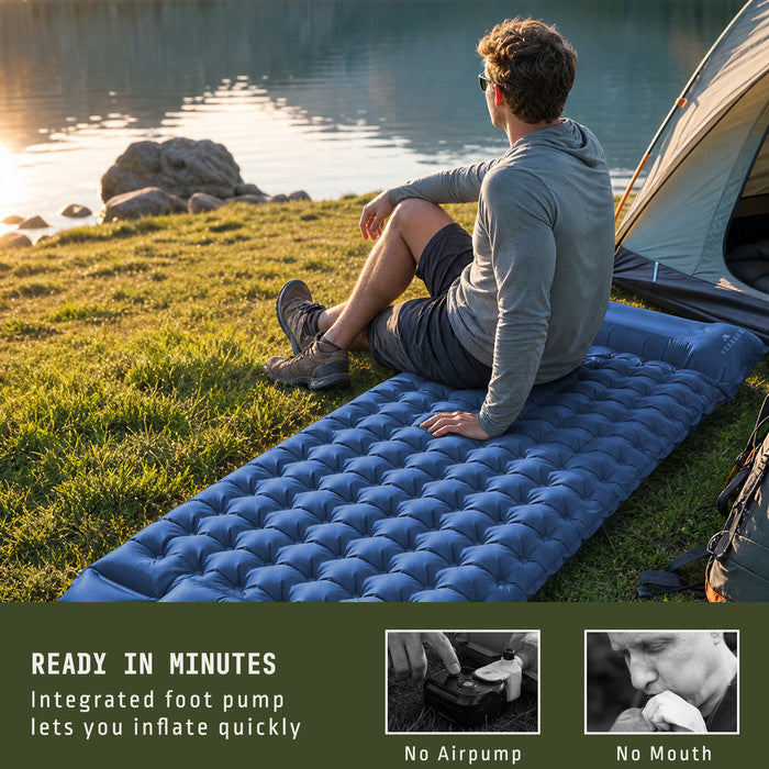 Man relaxing on Voyager blue inflatable camping mat by lakeside tent