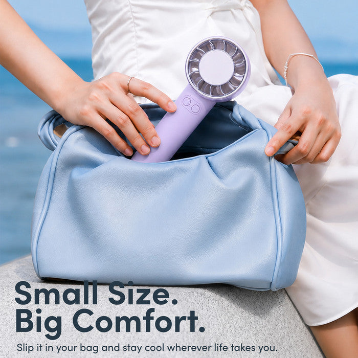 Lavender mini portable fan being placed into handbag – compact travel size