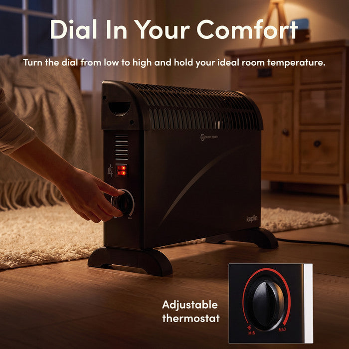 Adjusting thermostat dial on black convector heater from min to max