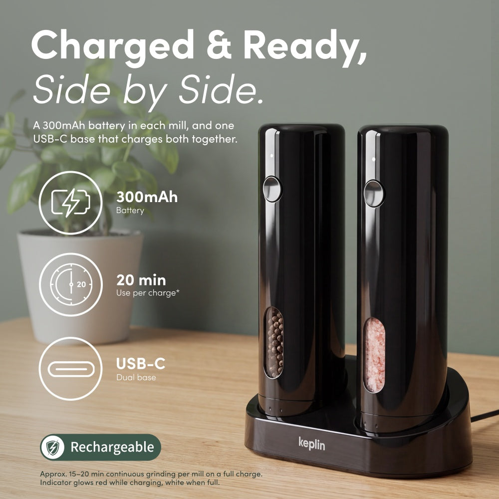 Two black mills charging side by side on a USB-C dual base with battery and runtime icons