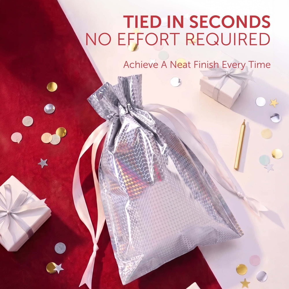 Silver textured foil gift bag with satin ribbon, surrounded by confetti and small gift boxes