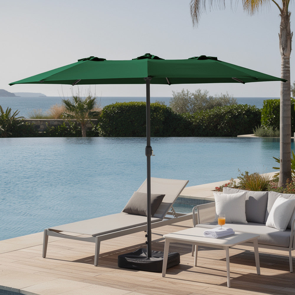 Green double garden parasol providing shade beside a swimming pool with sun loungers