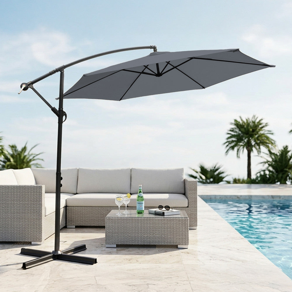 Grey 3m cantilever garden parasol providing shade beside a swimming pool with rattan outdoor sofa set