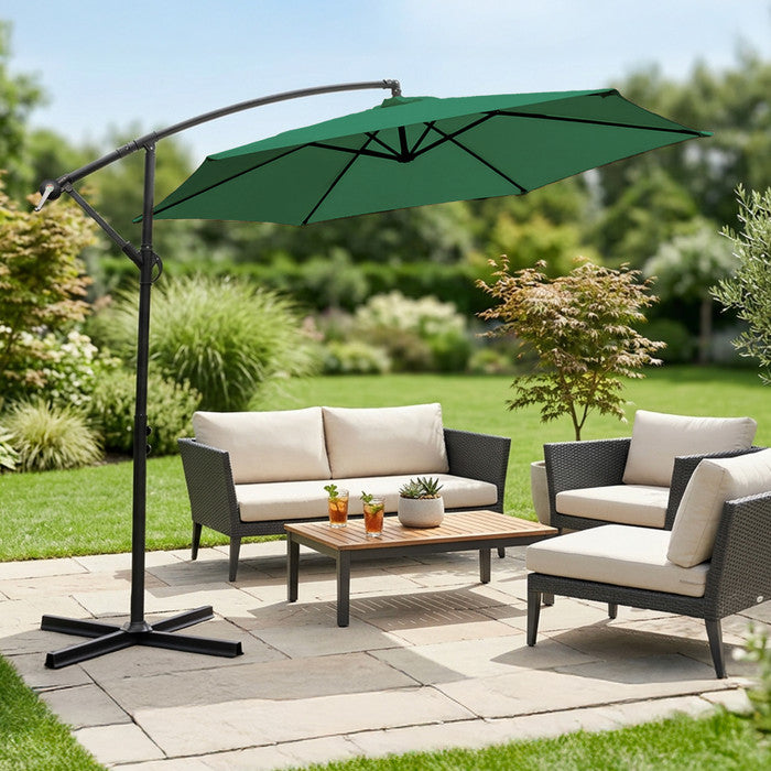 Green 3m cantilever garden parasol over rattan garden lounge set on a patio with lush garden backdrop
