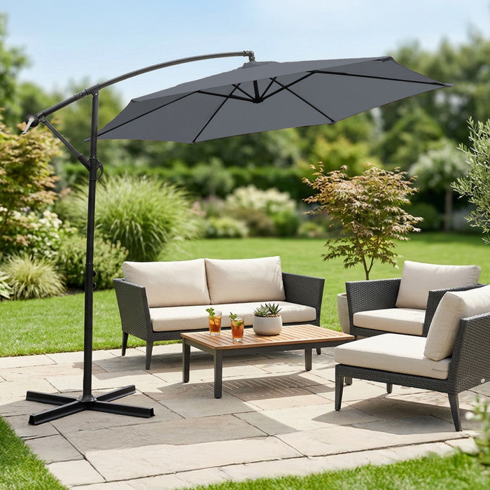 Grey 3m cantilever garden parasol over rattan garden lounge set on a patio with lush garden backdrop