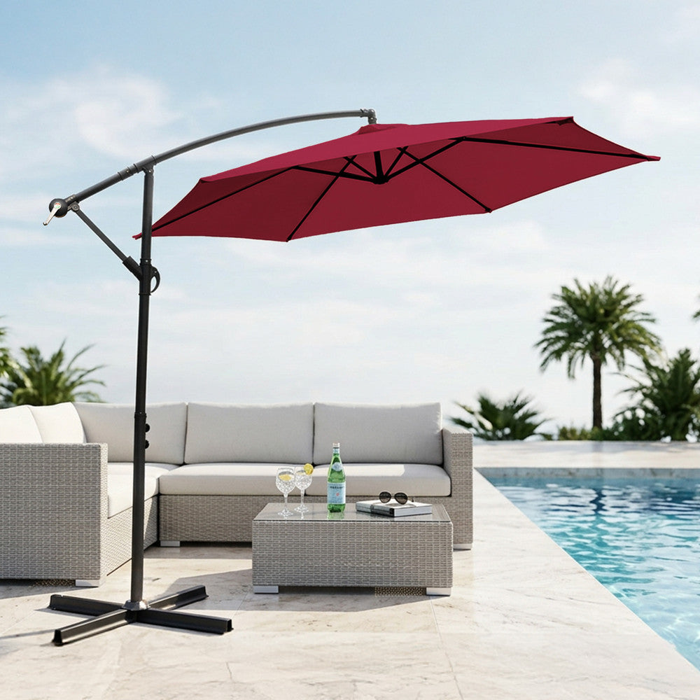 Burgundy 3m cantilever garden parasol providing shade beside a swimming pool with rattan outdoor sofa set