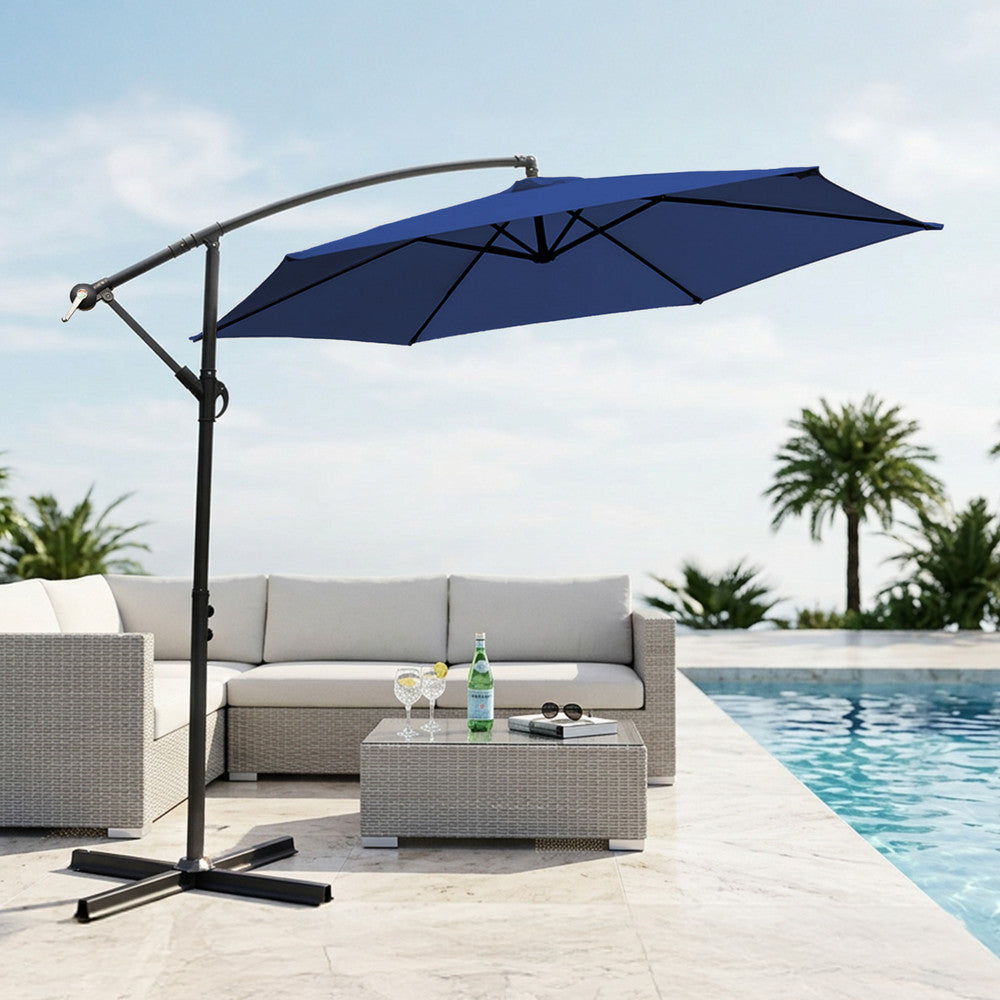 Navy blue 3m cantilever garden parasol providing shade beside a swimming pool with rattan outdoor sofa set