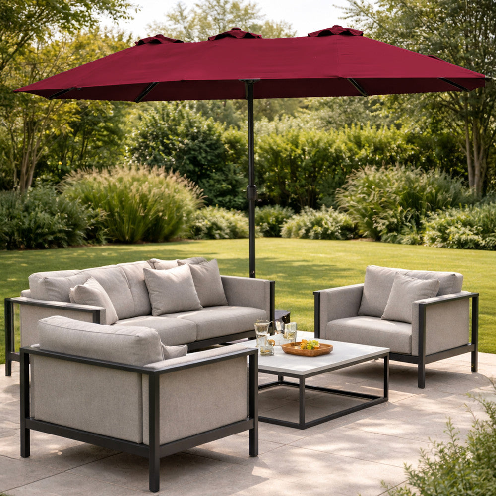 Red double garden parasol providing shade beside a swimming pool with sun loungers